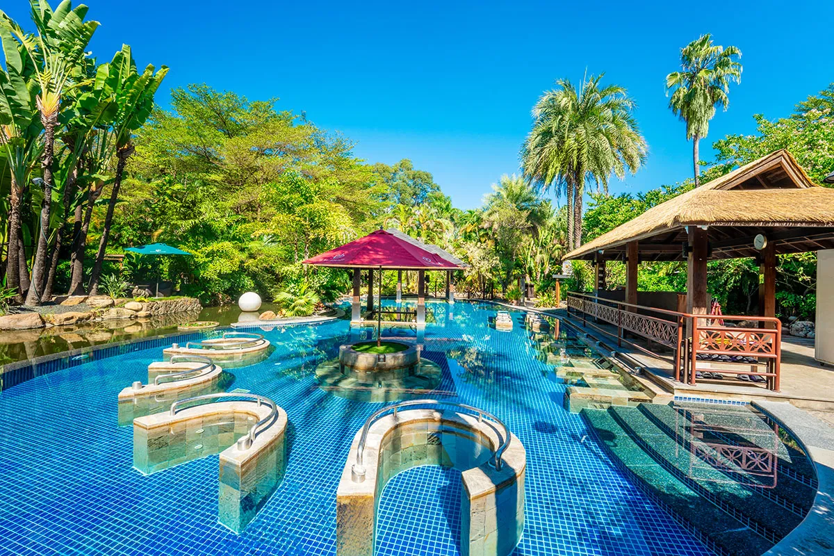 View of the Lotus Island water therapy pool at Riyuegu Hotsprings with surrounding pavilions and landscaped environment.