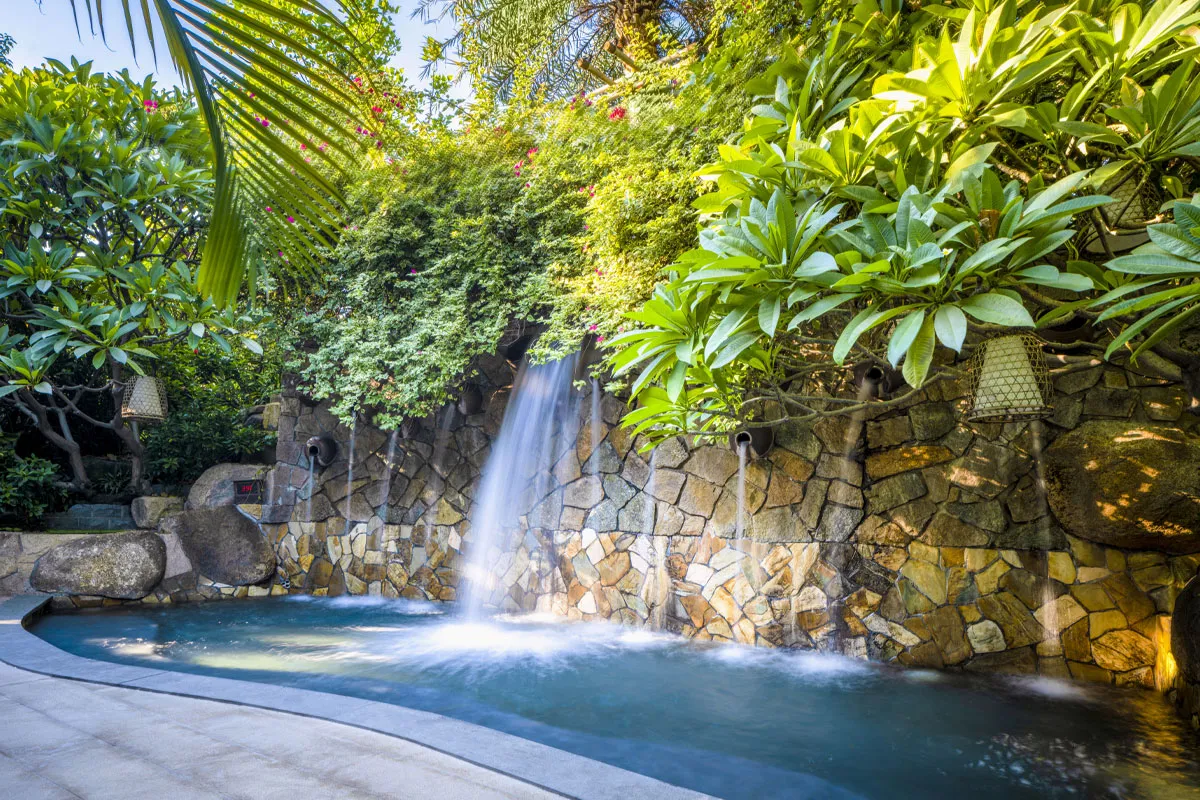 Hot spring pool with waterfall feature integrated into a landscaped setting at Riyuegu Hotsprings.