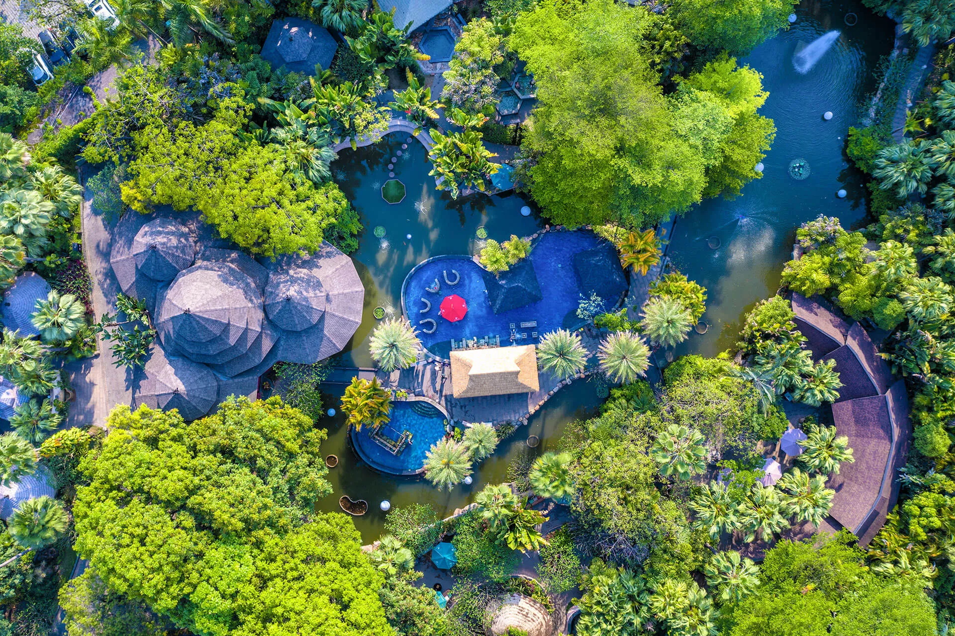 View of the Lotus Island water therapy pool at Riyuegu Hotsprings with surrounding pavilions and landscaped environment.