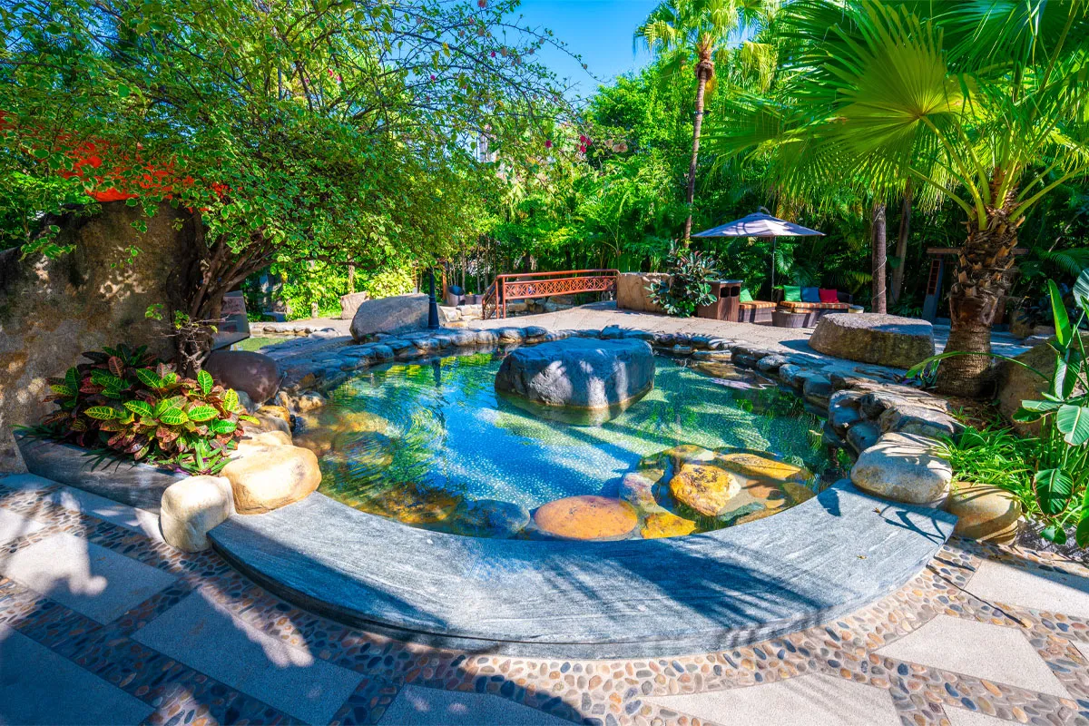 Open-air circular natural rock hot spring pool set within landscaped gardens at Riyuegu Hotsprings.